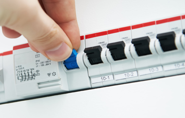 Circuit breaker being switched on a distribution board